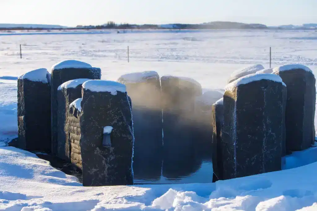 Soak in basalt stone hot pool at Torfus Retreat.